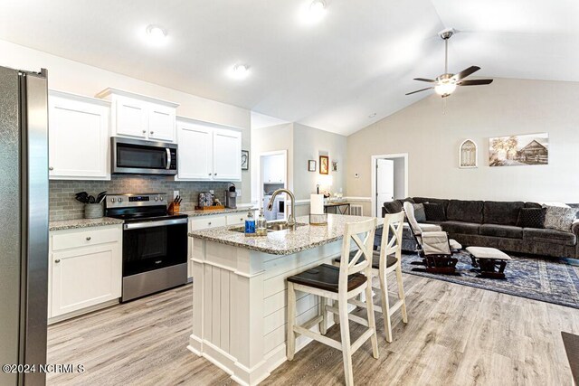 kitchen featuring light hardwood / wood-style floors, sink, an island with sink, white cabinets, and ceiling fan