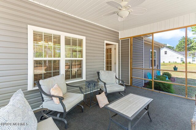 sunroom with ceiling fan, wood ceiling, and plenty of natural light