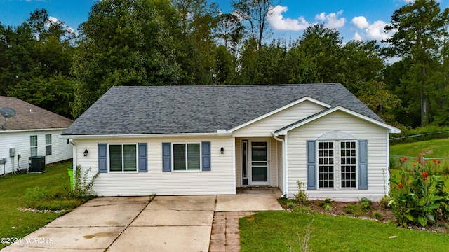 single story home with a front yard, central AC, and roof with shingles