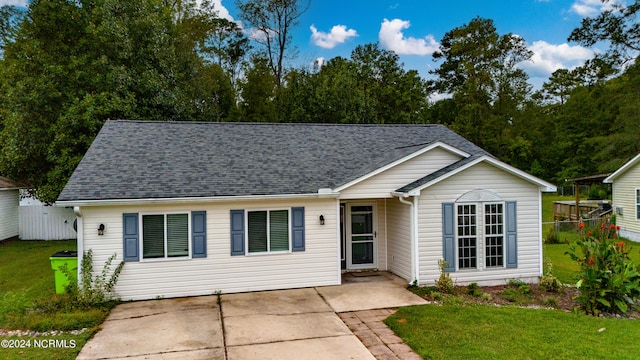 ranch-style house with a front lawn, a patio area, fence, and roof with shingles