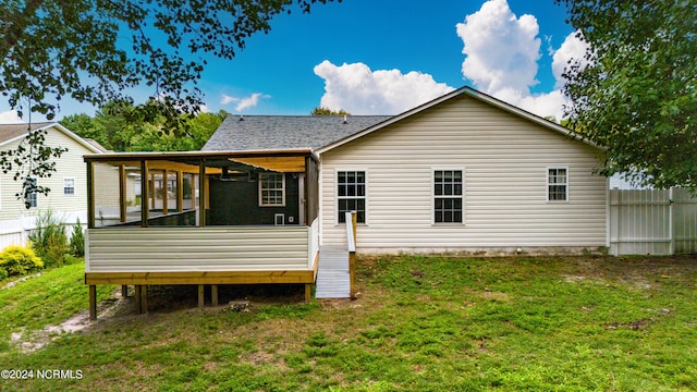 rear view of property with a yard, ceiling fan, and a sunroom