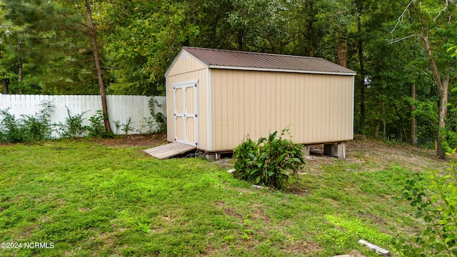 view of shed with a wooded view and fence