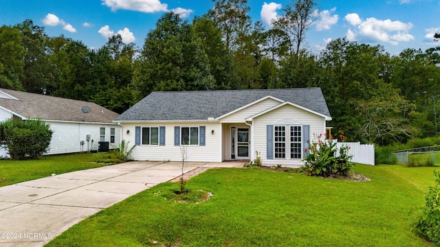 ranch-style home with central AC unit, roof with shingles, a front lawn, and fence