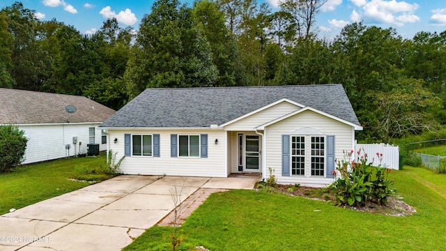 single story home with central AC unit, roof with shingles, a front yard, and fence