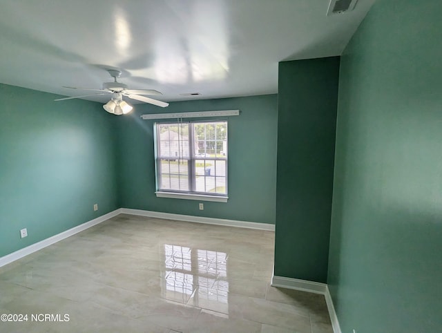 spare room with ceiling fan and light tile patterned flooring