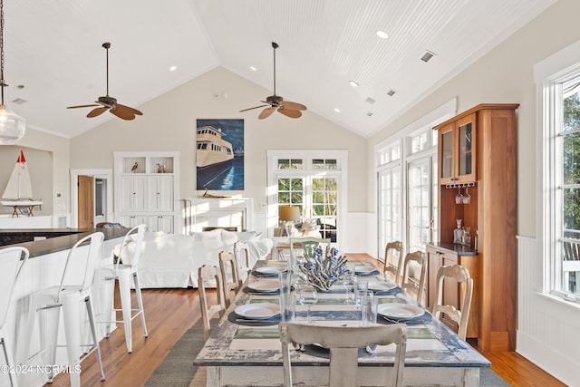 dining room featuring ceiling fan, light hardwood / wood-style floors, and high vaulted ceiling