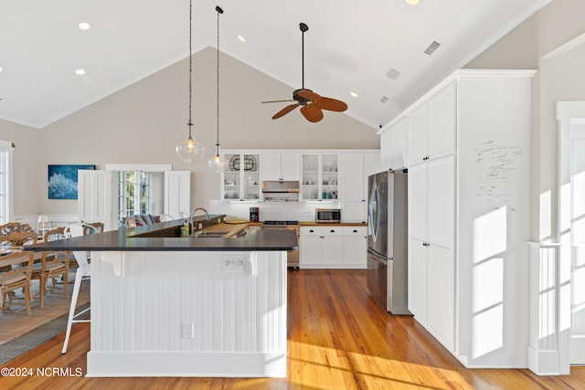 kitchen with sink, high vaulted ceiling, white cabinetry, stainless steel appliances, and light wood-type flooring