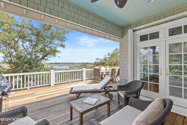 deck with french doors and a water view