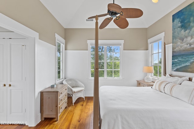 bedroom with a closet, light wood-type flooring, lofted ceiling, and ceiling fan