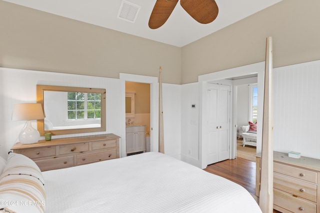 bedroom featuring a closet, dark wood-type flooring, sink, connected bathroom, and ceiling fan