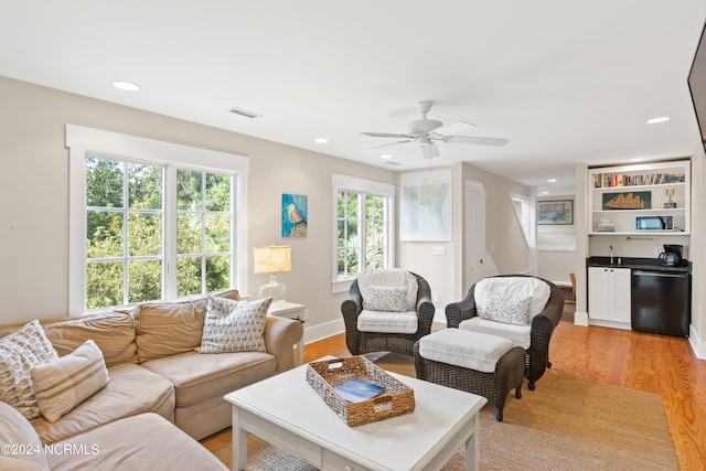 living room with ceiling fan and light hardwood / wood-style flooring