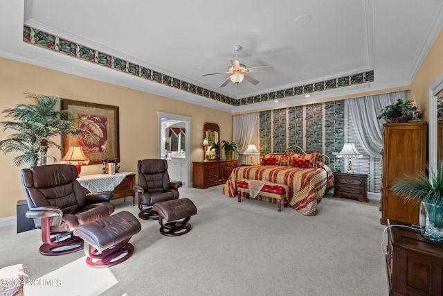 carpeted bedroom with a tray ceiling, ornamental molding, and ceiling fan