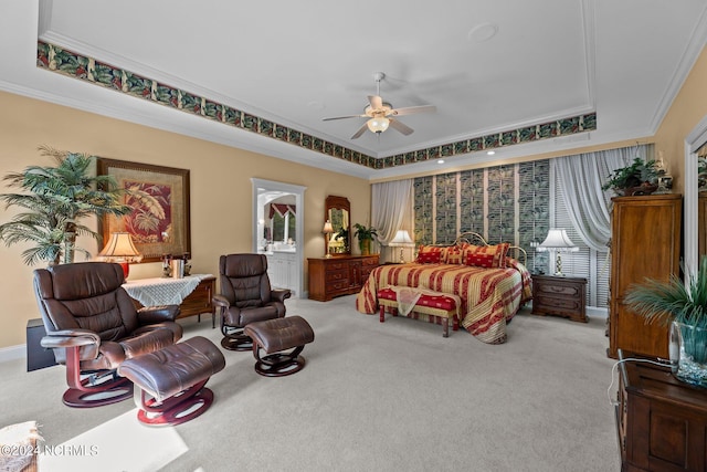 carpeted bedroom featuring a tray ceiling, crown molding, and ceiling fan