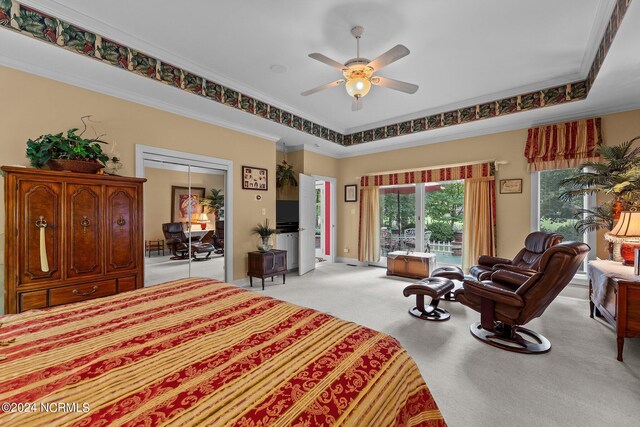 bedroom featuring light colored carpet, ornamental molding, a raised ceiling, access to exterior, and a ceiling fan