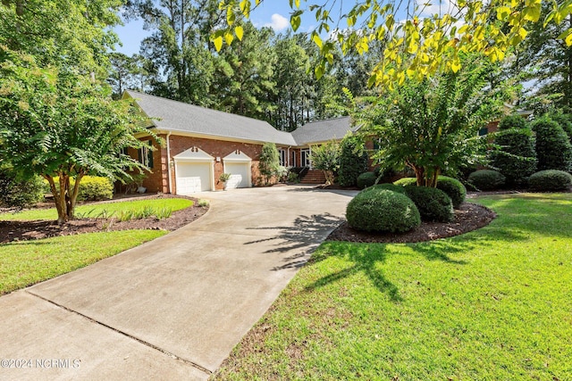 ranch-style house featuring a garage, driveway, brick siding, and a front yard