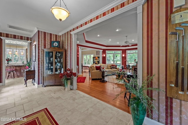 entryway featuring light wood-type flooring, crown molding, bar area, and ceiling fan