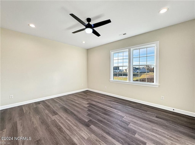 spare room featuring dark hardwood / wood-style flooring and ceiling fan