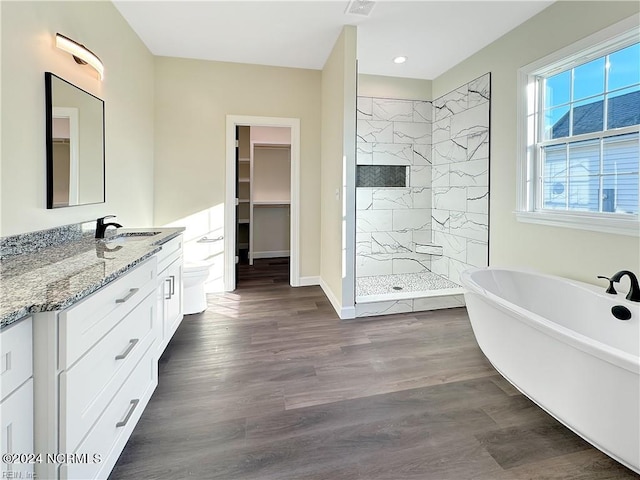 bathroom with independent shower and bath, vanity, and hardwood / wood-style floors