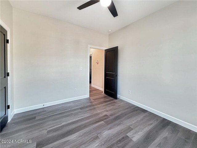 empty room featuring dark hardwood / wood-style flooring and ceiling fan