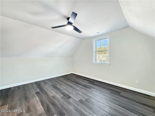 bonus room featuring a textured ceiling, vaulted ceiling, dark hardwood / wood-style flooring, and ceiling fan