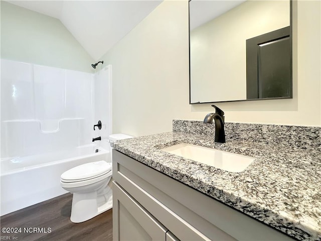 full bathroom with vanity, wood-type flooring, vaulted ceiling, shower / tub combination, and toilet