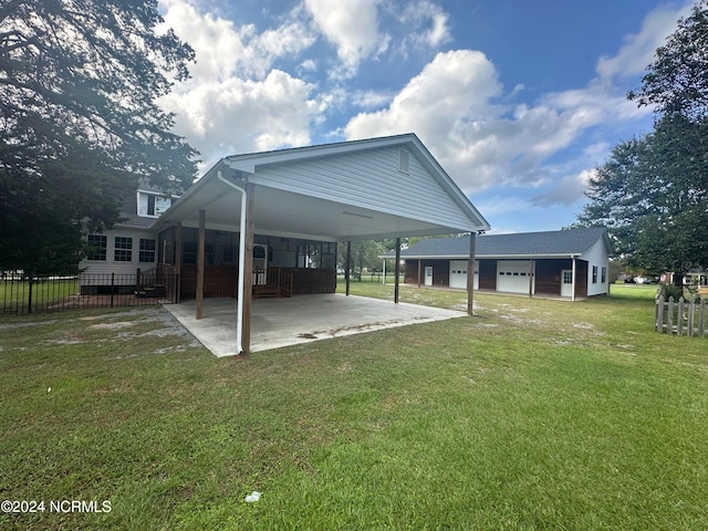 back of house featuring a garage, a porch, a lawn, and a carport