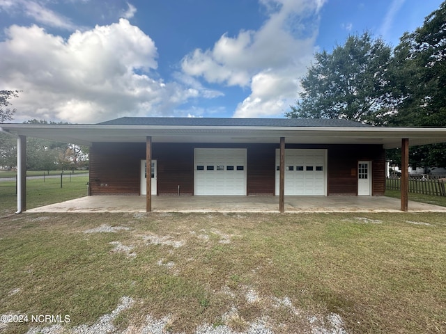 garage featuring a lawn and a carport