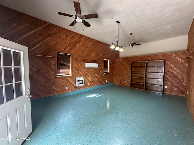 bonus room featuring heating unit, wooden walls, a wall mounted AC, and ceiling fan