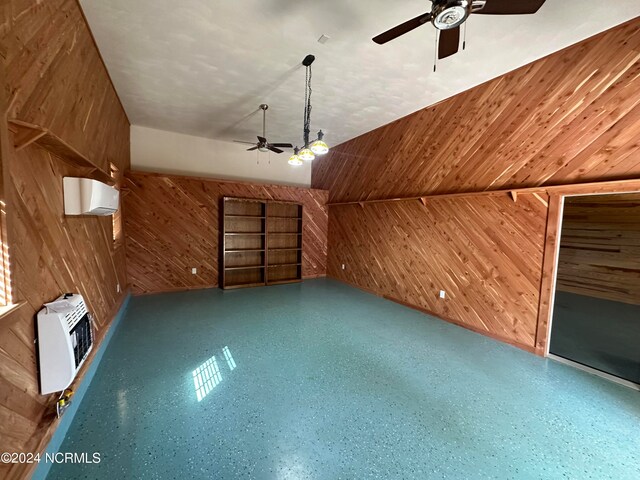 bonus room with heating unit, ceiling fan, built in features, wooden walls, and a wall mounted AC