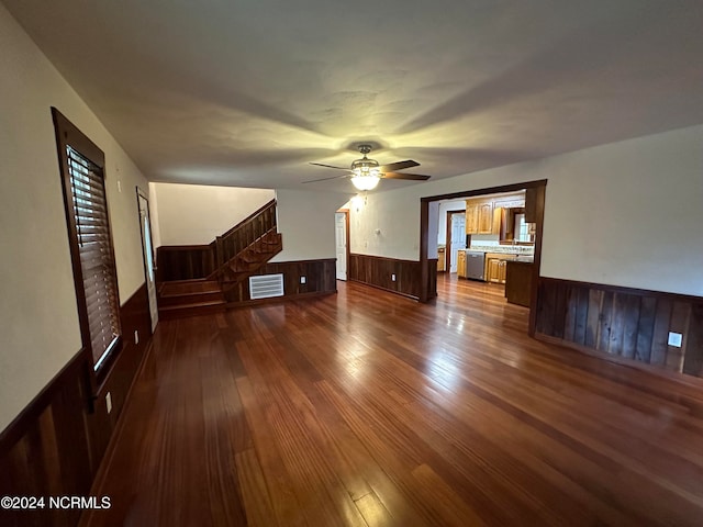 unfurnished room with wood walls, dark hardwood / wood-style flooring, and ceiling fan