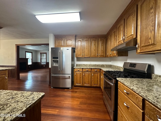 kitchen featuring light stone counters, appliances with stainless steel finishes, and dark hardwood / wood-style flooring