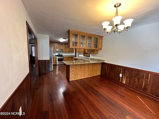 kitchen featuring sink, kitchen peninsula, stainless steel appliances, an inviting chandelier, and dark hardwood / wood-style flooring