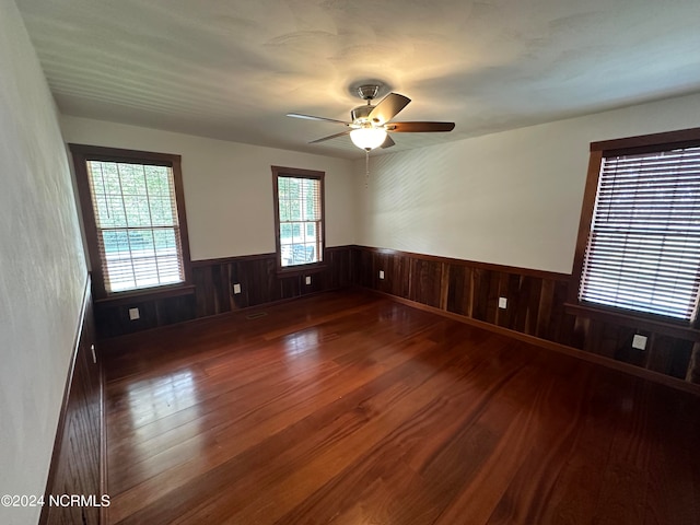 spare room with wood walls and dark wood-type flooring