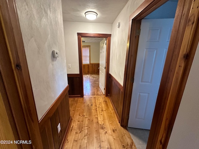 additional living space featuring light wood-type flooring, wood walls, vaulted ceiling, and ceiling fan