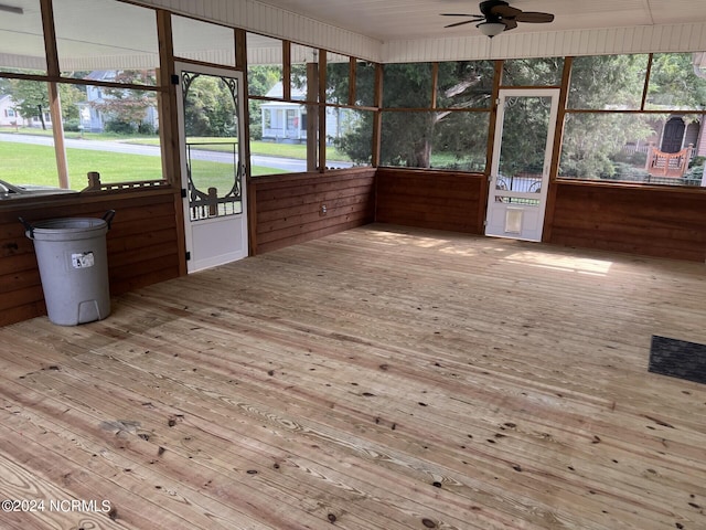 unfurnished sunroom featuring ceiling fan and a wealth of natural light