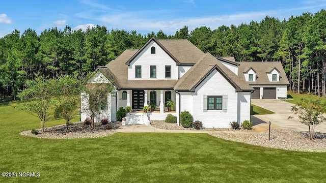 view of front facade featuring covered porch, a front lawn, and a garage