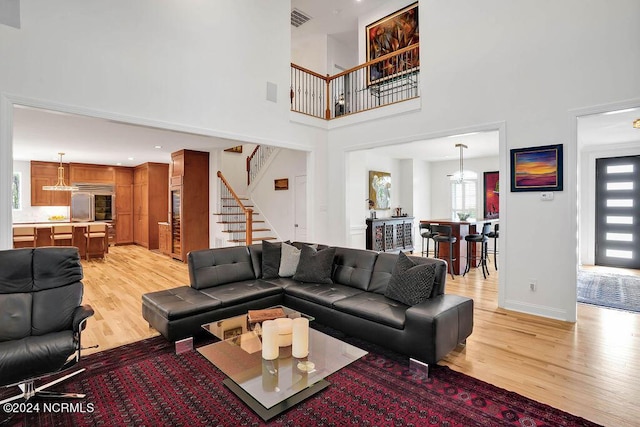 79 Bishop Branch Ln SE, Leland, NC 28451 - living area featuring light wood-style floors, stairway, a towering ceiling, and baseboards