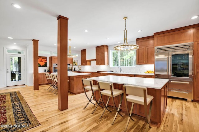 79 Bishop Branch Ln SE, Leland, NC 28451 - kitchen with stainless steel built in fridge, a center island, light wood-style flooring, plenty of natural light, and recessed lighting