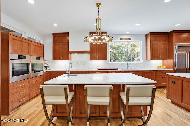 79 Bishop Branch Ln SE, Leland, NC 28451 - kitchen with appliances with stainless steel finishes, a sink, brown cabinets, light wood finished floors, and recessed lighting