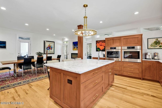 79 Bishop Branch Ln SE, Leland, NC 28451 - kitchen with oven, a sink, light wood finished floors, a chandelier, and crown molding