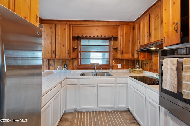 kitchen featuring light wood-type flooring, appliances with stainless steel finishes, sink, and white cabinets