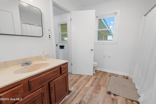 bathroom with ornamental molding, hardwood / wood-style floors, vanity, and toilet