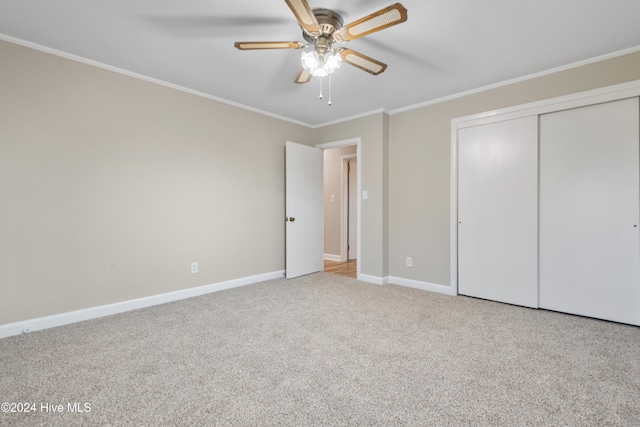 unfurnished bedroom with ornamental molding, light carpet, ceiling fan, and a closet