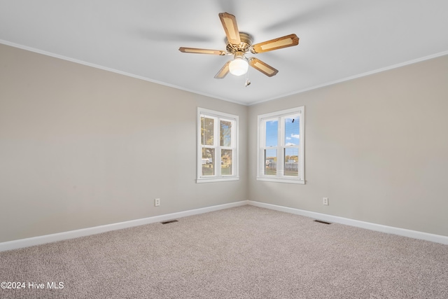 carpeted spare room featuring ceiling fan and ornamental molding