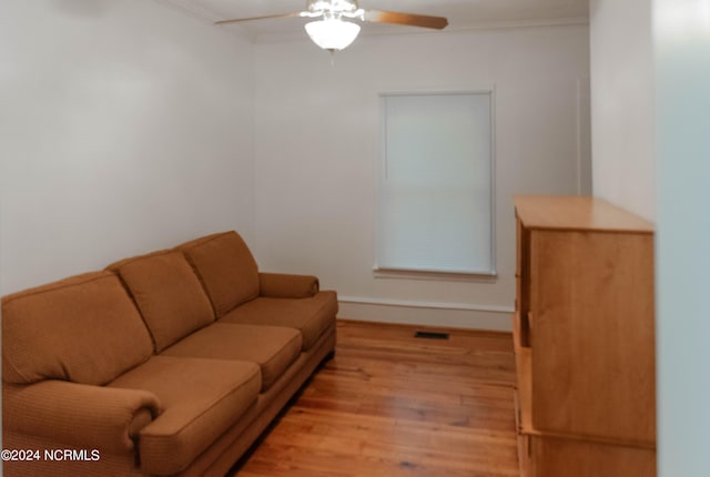 living room with crown molding, ceiling fan, and light hardwood / wood-style flooring