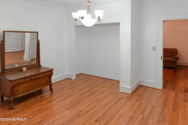 interior space with a chandelier, light hardwood / wood-style floors, and crown molding