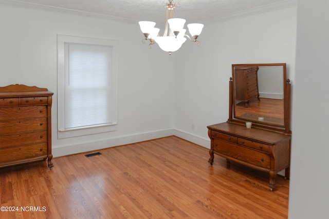 miscellaneous room with ornamental molding, a textured ceiling, light wood-type flooring, and a chandelier