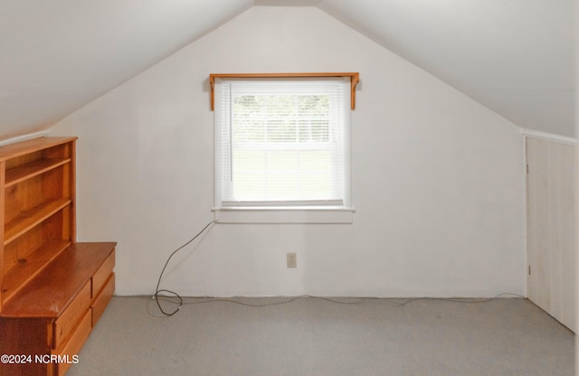 bonus room featuring light carpet and vaulted ceiling