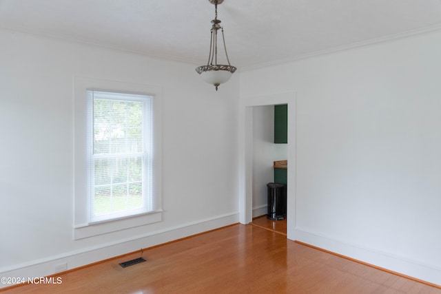 unfurnished room featuring ornamental molding and hardwood / wood-style floors