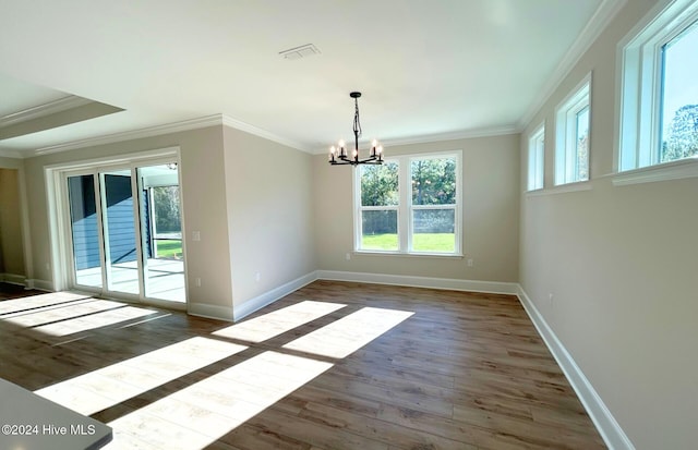 unfurnished dining area featuring crown molding, a healthy amount of sunlight, dark hardwood / wood-style flooring, and a notable chandelier